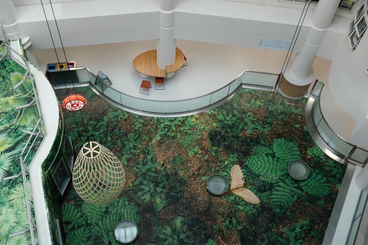 Looking down into the Starship atrium, with a forest floor mural and sculptures hanging above it.